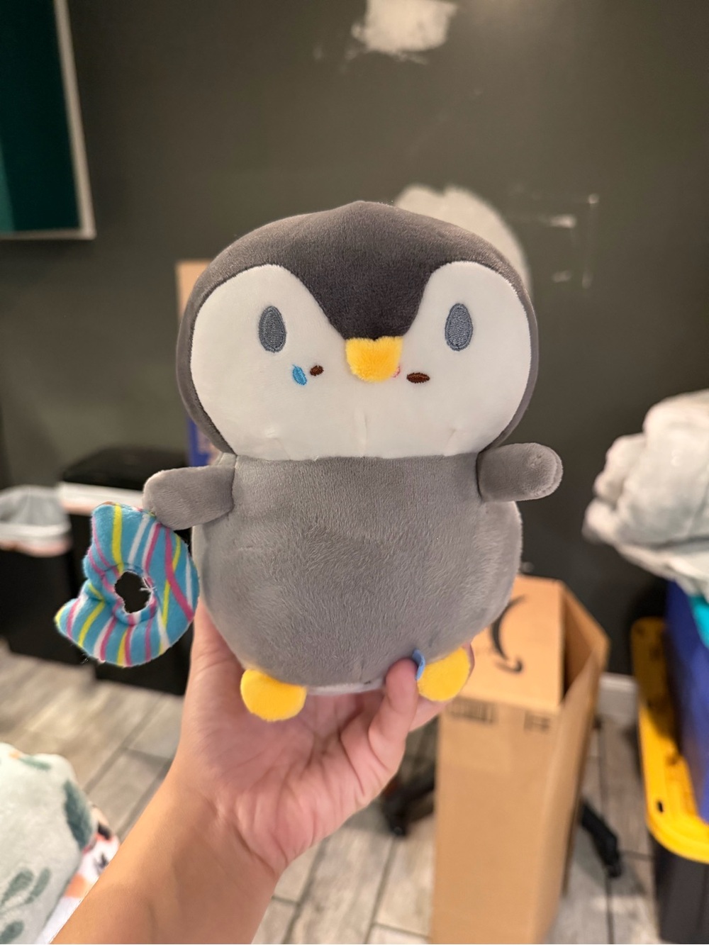 Gray Penguin Plush with Yellow Beak & Feet with a Donut and has a suction cup